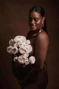 seance photo avec une femme enceinte afro et des fleurs