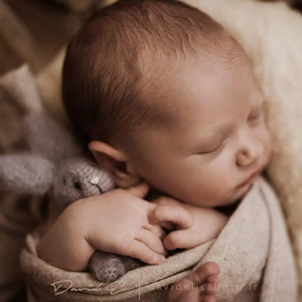 bebe qui pose avec un doudou