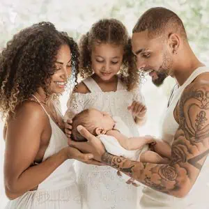 stat du football qui pose avec son bébé et sa famille