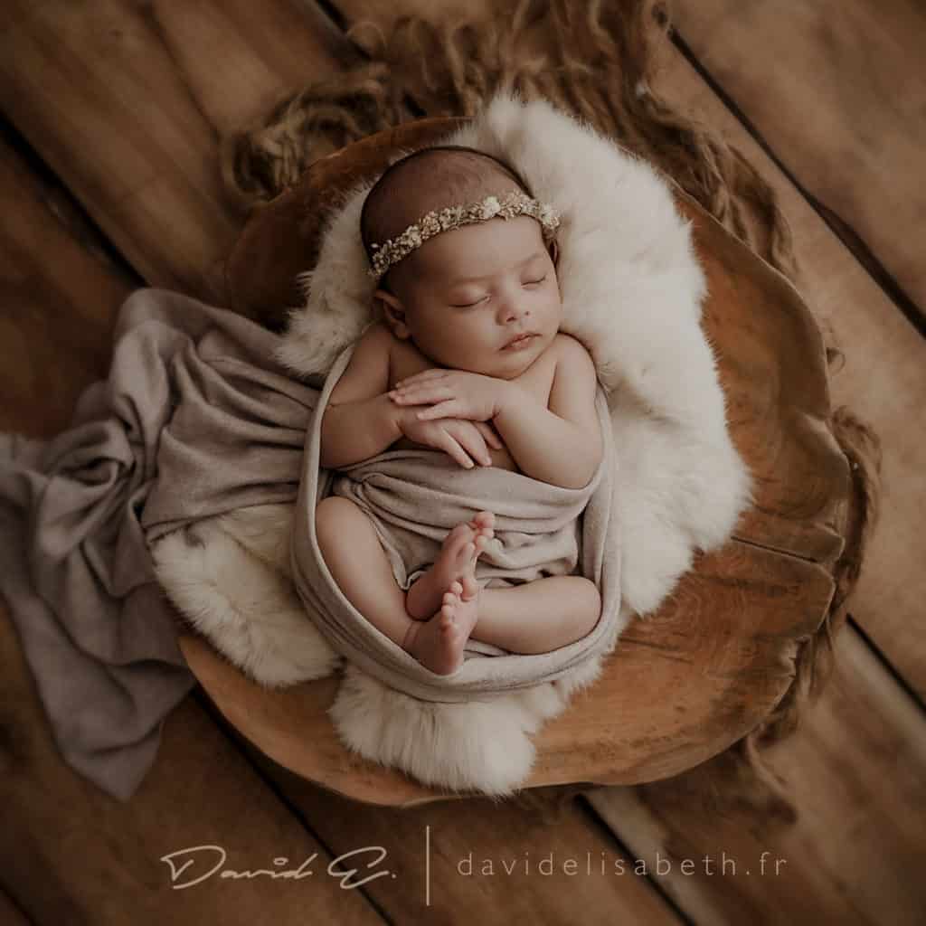 newborn baby posing inside a wood props
