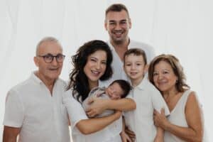 Portrait de famille au studio avec un nouveau-né dans les bras de sa maman