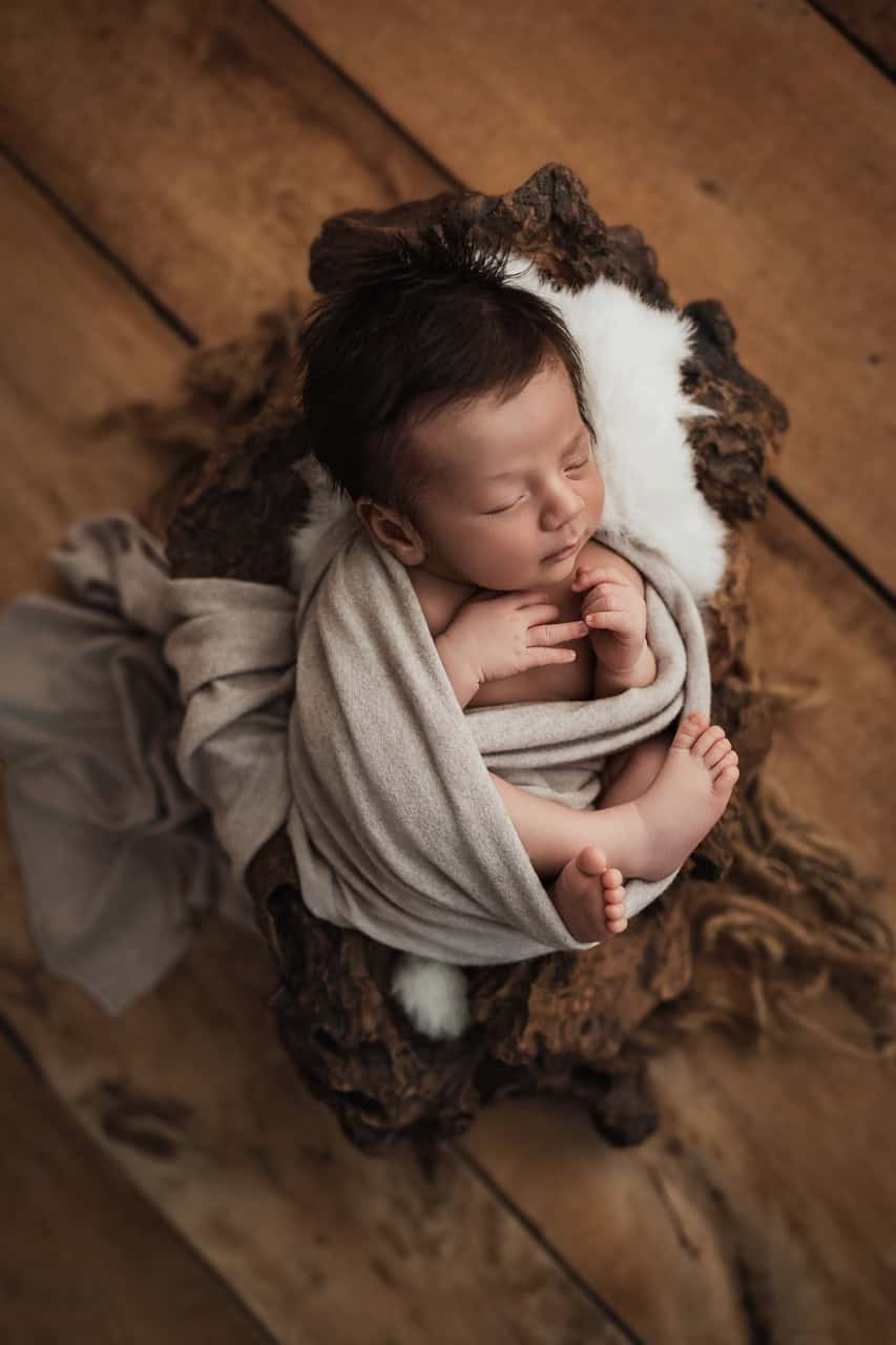 Nouveau-né endormi dans un décor chaleureux de studio naissance