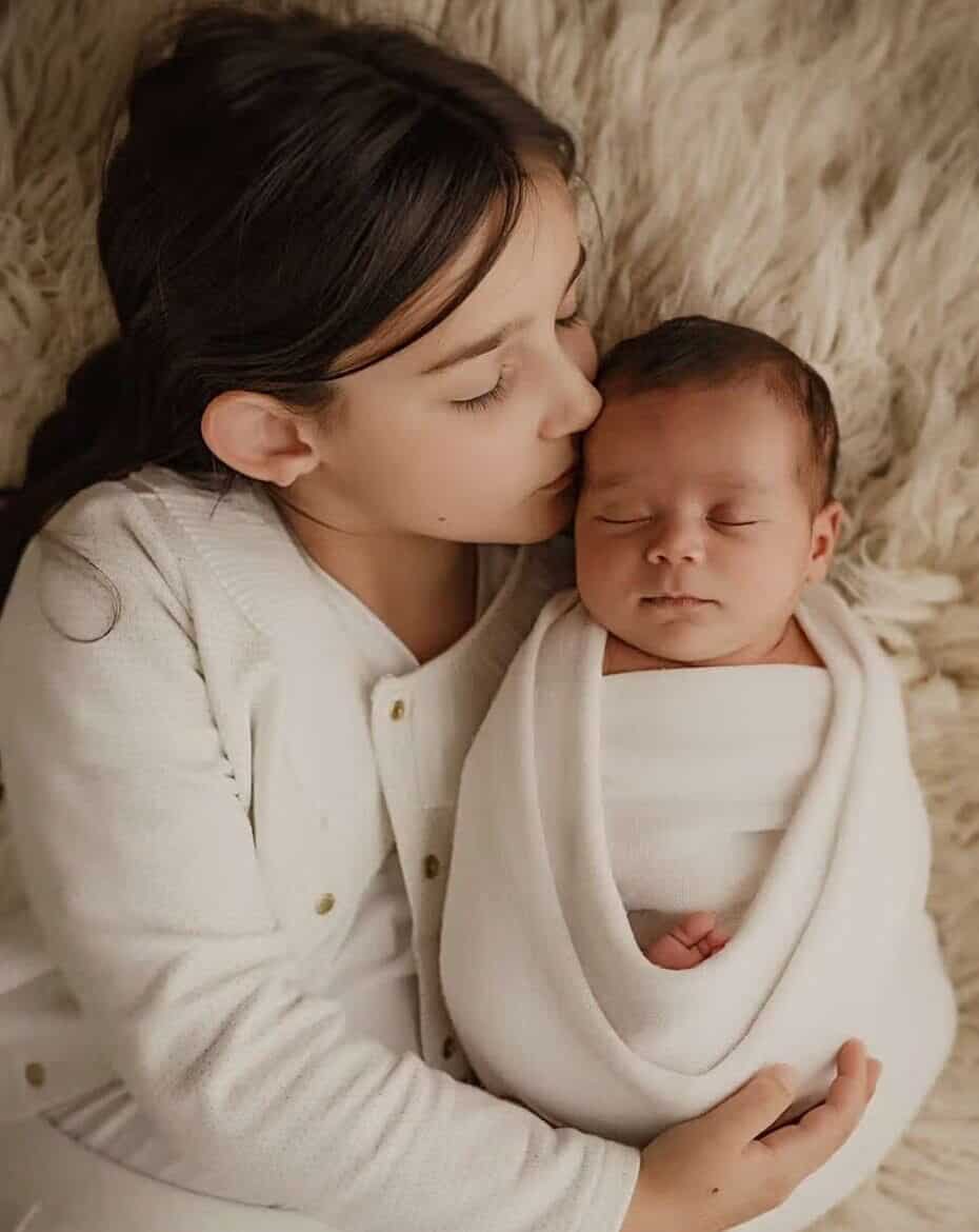 Photo de bébé emmailloté avec sa fratrie au studio